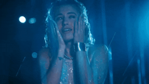 a woman with a ring on her finger is covered in blue glitter