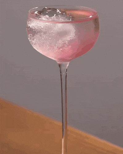 a rose shaped ice cube is being poured into a champagne glass