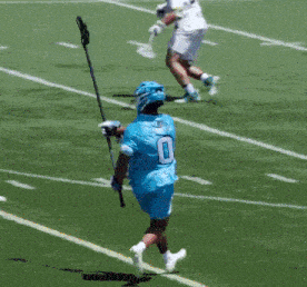 a lacrosse game is being played on a field with the letter r on the sidelines