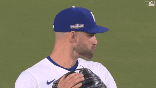 a baseball player wearing a blue dodgers hat and glove