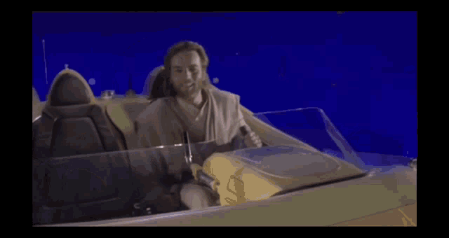 a man is sitting in a speeder with a blue background