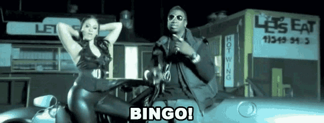 a man and a woman are sitting on top of a car with the word bingo written on the bottom