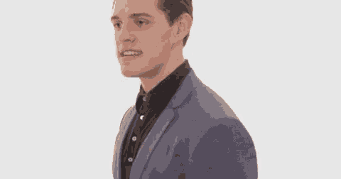 a man in a suit and tie is running and making a face .