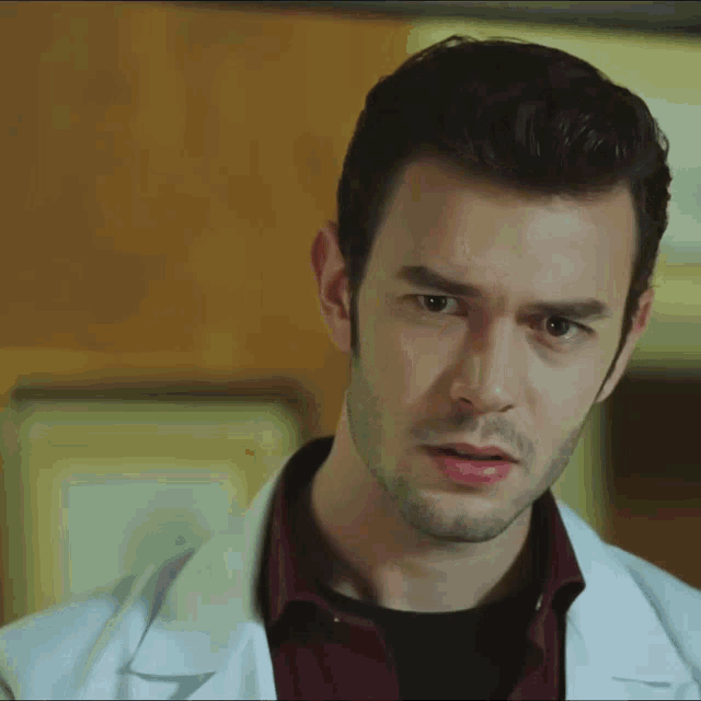 a close up of a man 's face wearing a white coat