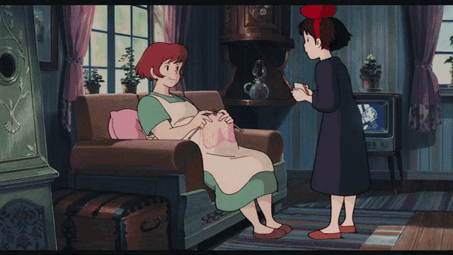 a woman sitting on a couch talking to a girl with a red bow on her head