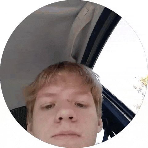 a man is taking a picture of himself in a circle while sitting in a car .