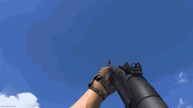 a person is holding a gun in front of a blue sky