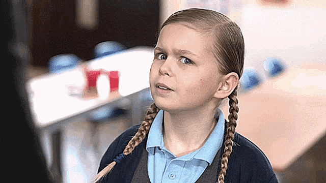 a young girl with braids looks up at something