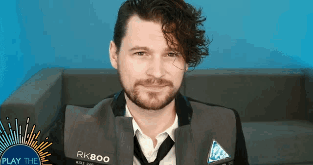 a man with a beard wears a jacket that says rk800 on it