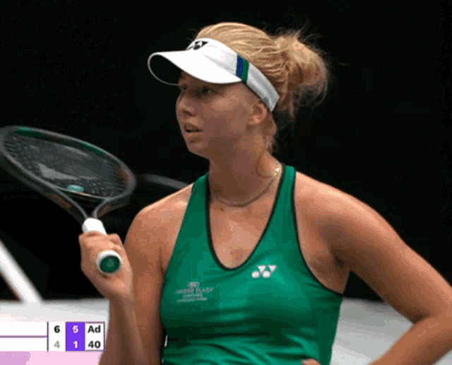 a woman holding a tennis racquet in front of a scoreboard that says ad