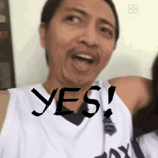 a man wearing a white shirt that says yes
