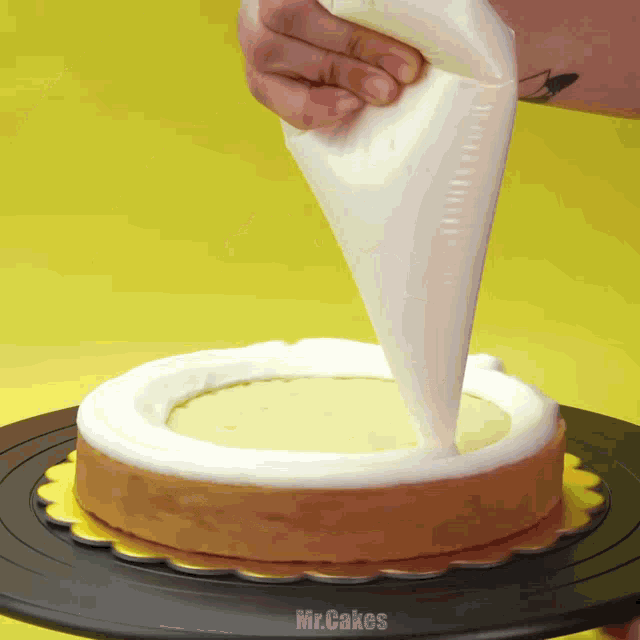 a person is frosting a cake with mr.cakes written on the bottom