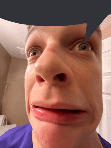 a close up of a man 's face with a blue speech bubble above his head