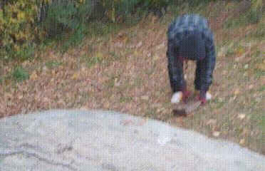 a person is kneeling down on the ground in a field .