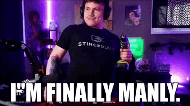 a man wearing headphones is holding a drill and says `` i 'm finally manly ''