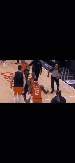 a group of basketball players on a court with a nba finals sign in the background .