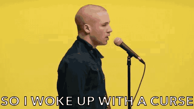 a man singing into a microphone with the words so i woke up with a curse