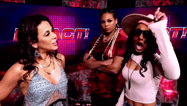 three women are standing in front of a sign that says i act