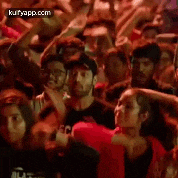 a group of people are dancing in a crowd at a party .