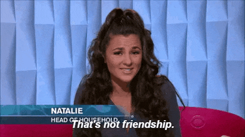 a woman is sitting on a red couch on a television show and talking about friendship .