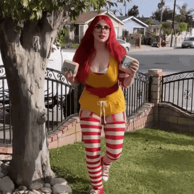 a woman with red hair and striped stockings is dressed as mcdonald 's worker