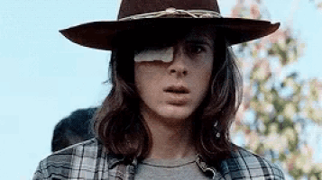 a young man wearing a hat and a bandage on his eye .