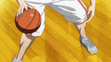 a basketball player dribbles the ball on a wooden floor