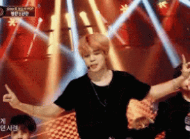 a man in a black shirt is dancing on a stage with a microphone .