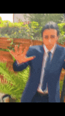 a man in a suit and tie is standing in front of a fence