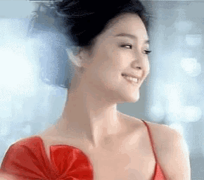 a woman in a red dress with a bow on her shoulder