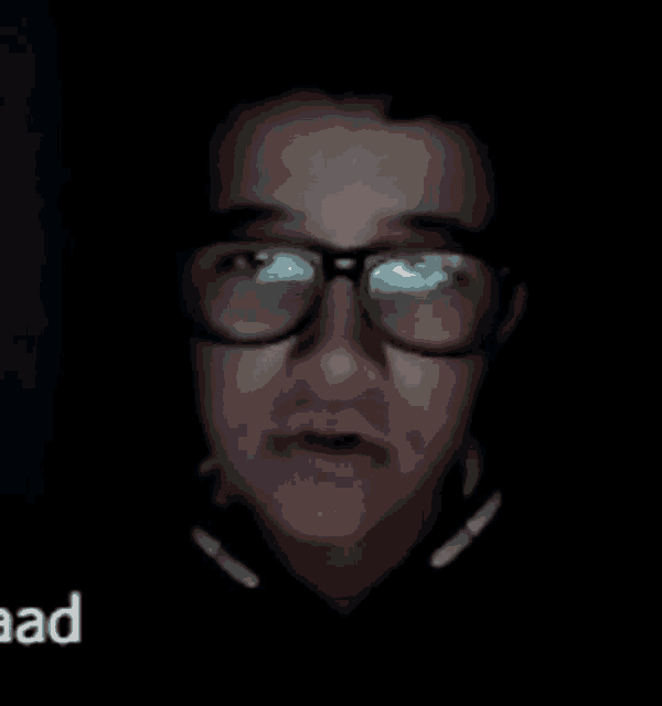a close up of a person wearing glasses and headphones with the word aad in the corner