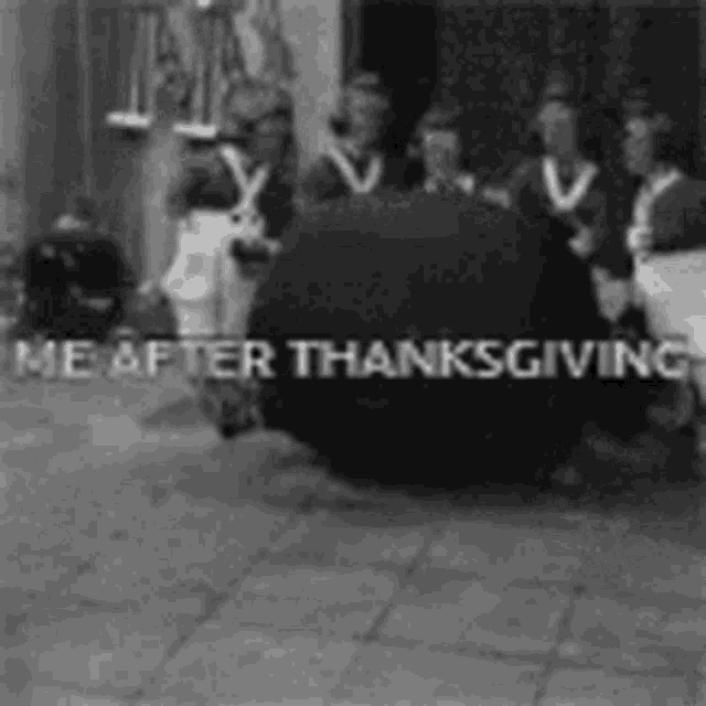 a group of people are standing around a large black object .