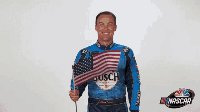 a man wearing a blue busch shirt holds an american flag
