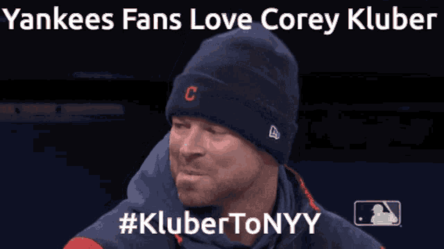 a yankees fan wearing a beanie with the letter c on it is smiling