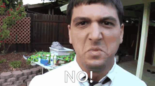 a man in a white shirt and tie has the word no written on his face