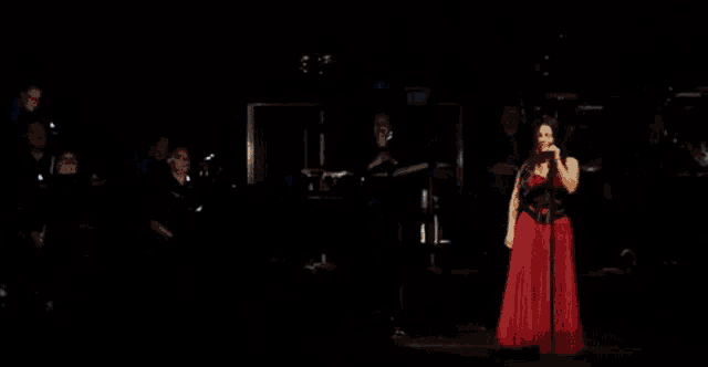 a group of people are standing on a stage in the dark with a lot of lights shining on them .