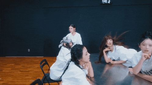 a group of girls are sitting around a table with one wearing a white shirt that says rider