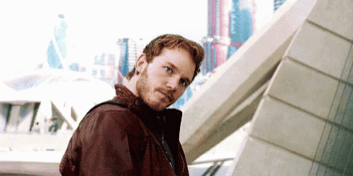 a man with a beard is standing in front of a building .