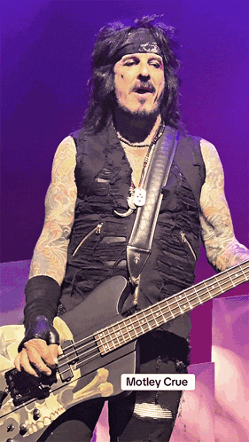 a picture of a man playing a guitar with the name motley crue on it