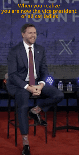 a man in a suit and tie sits on a stool in front of a brick wall that says when you realize