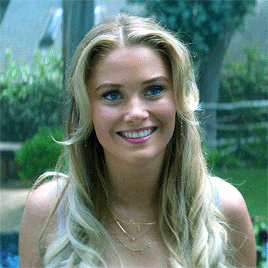 a woman with long blonde hair and blue eyes is smiling