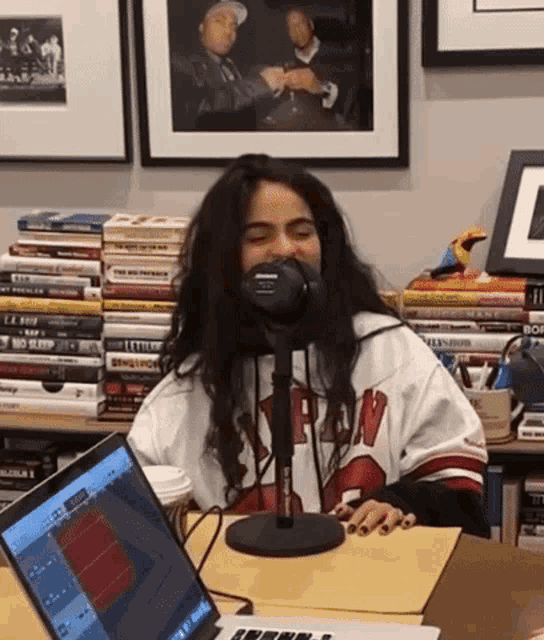a woman sitting in front of a microphone wearing a jersey that says ' bn ' on it