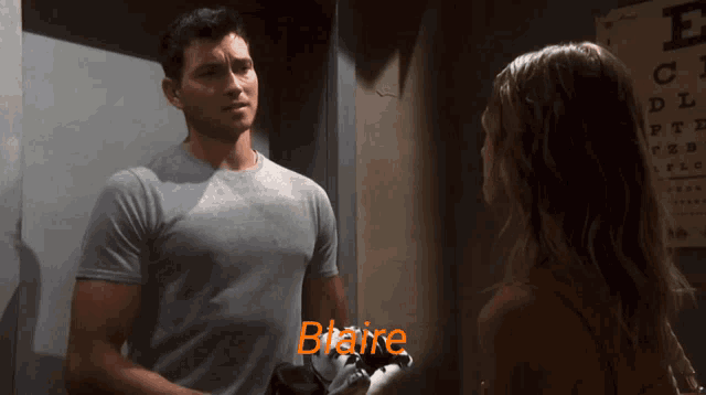 a man and woman are standing next to each other and the man 's shirt says blaine