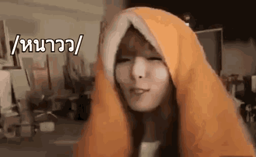 a woman is wearing a blanket on her head and making a funny face .