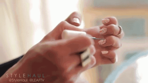 a woman is applying nail polish to her nails with a brush