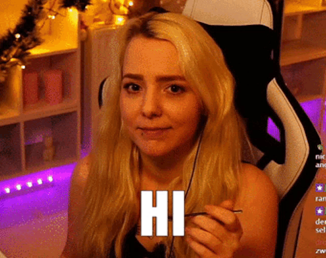a woman is sitting in a chair with headphones and the word hi on her face