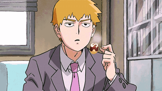 a man in a suit and tie is eating a candy
