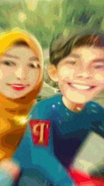 a boy and a girl are posing for a picture and the boy is wearing a shirt with the letter t on it