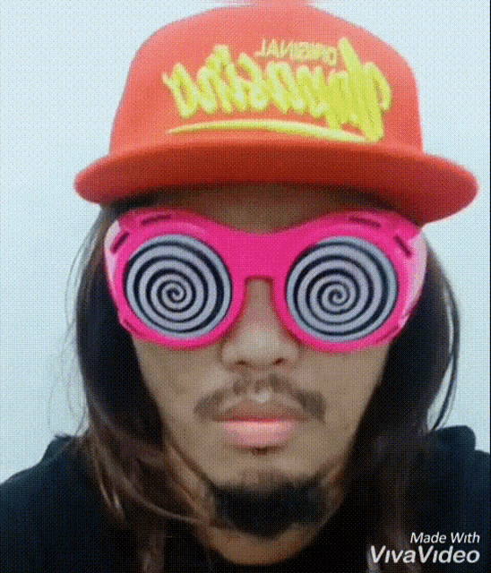 a man wearing a red hat and pink hypnotic glasses is made with vivavideo