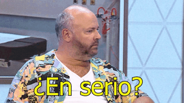 a man in a colorful shirt says " en serio "